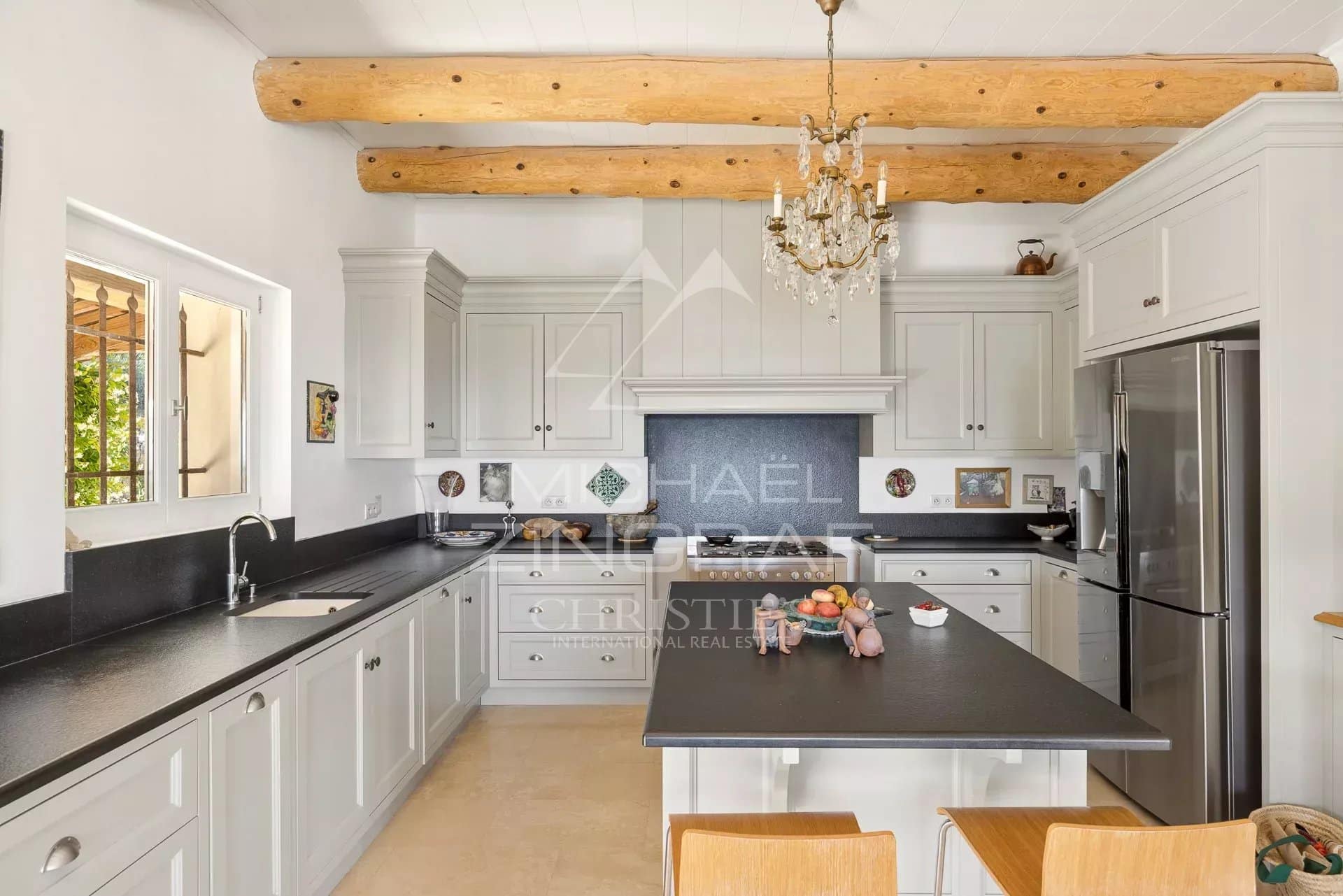 Cuisine élégante d’une villa à Vence Cuisine d'une villa provençale à Vence avec des poutres en bois et un îlot central