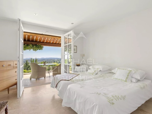 Chambre d'une villa provençale à Vence avec vue sur les collines et la mer.