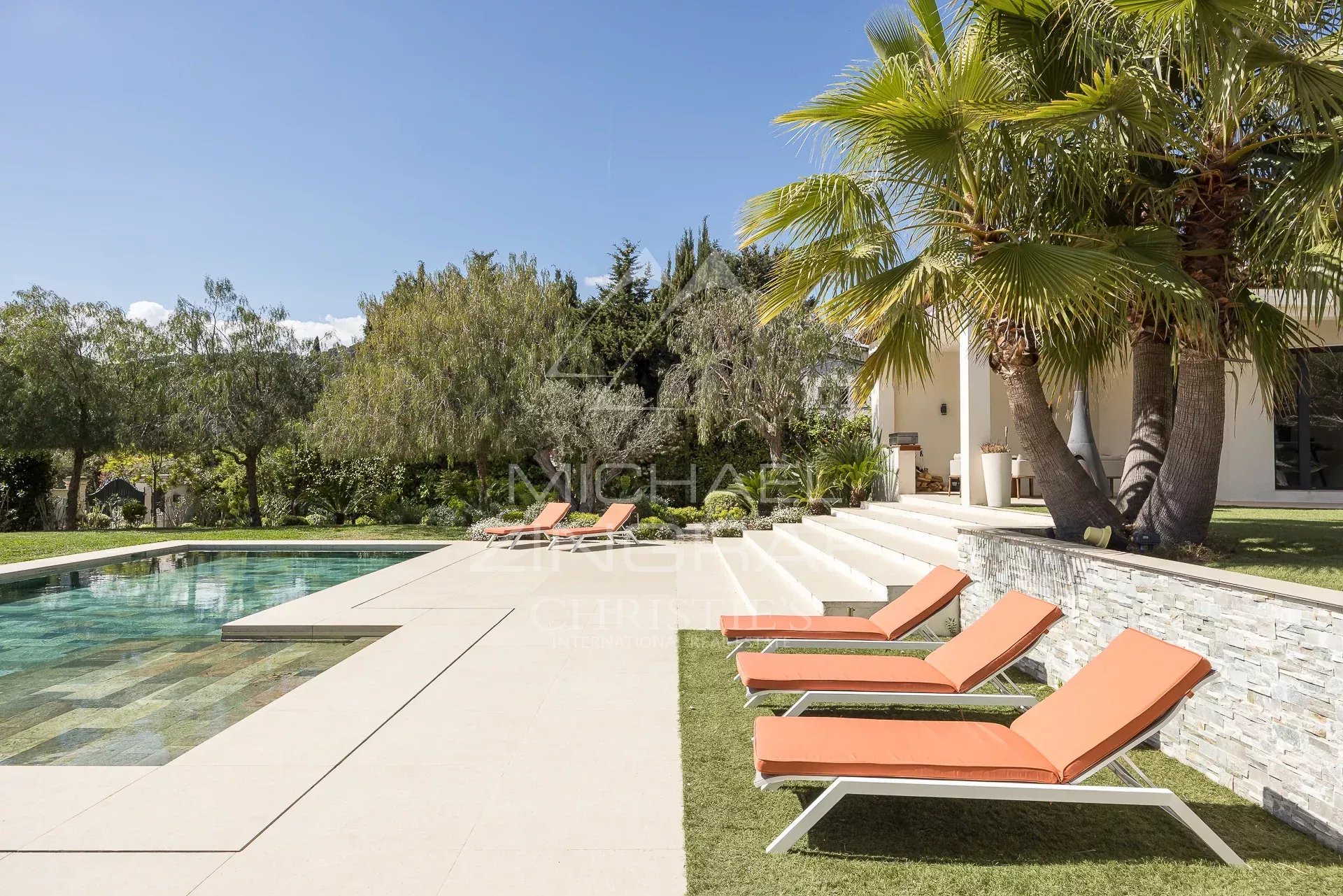 View of a contemporary villa with swimming pool and sun loungers in Saint-Paul-de-Vence.
