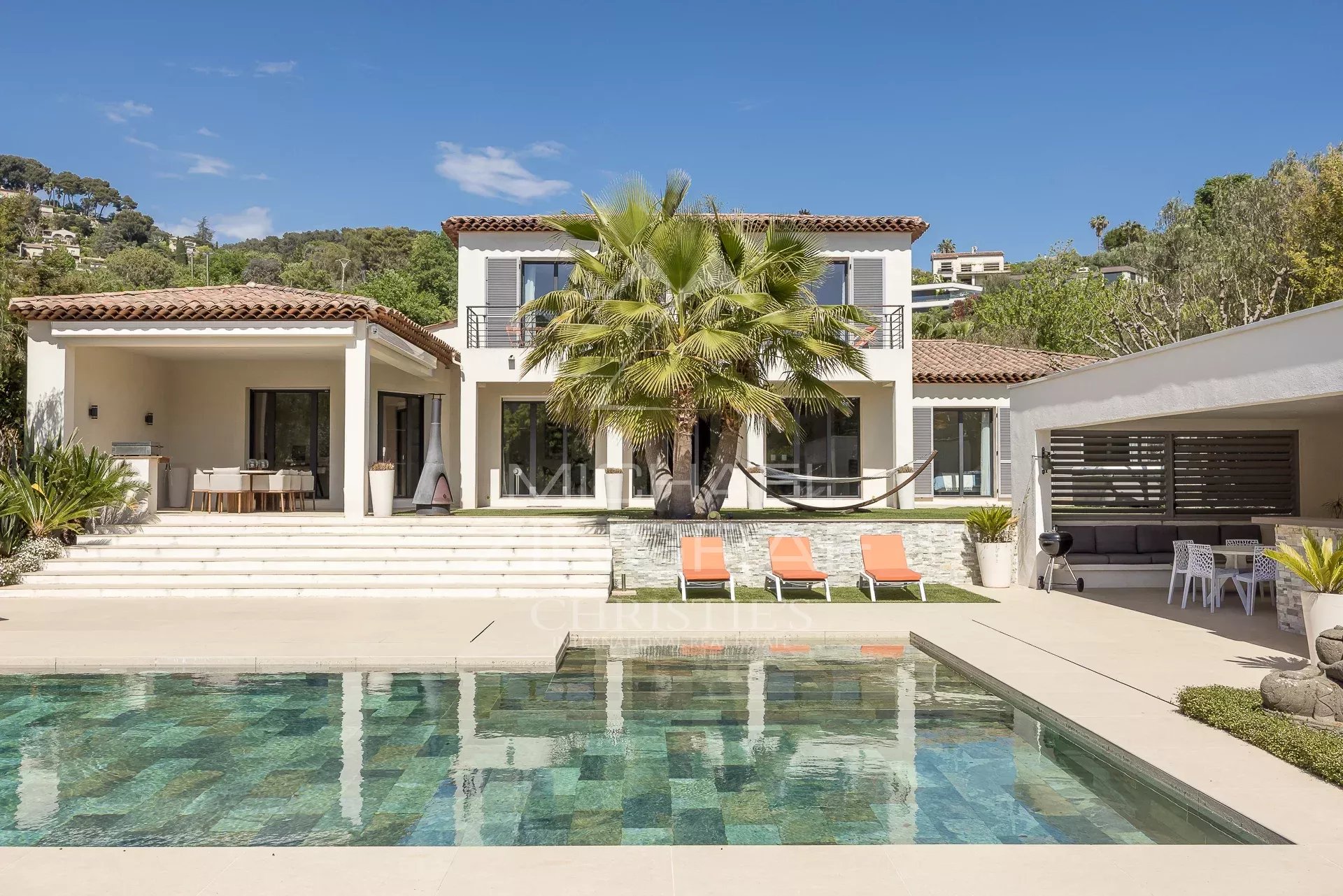 Contemporary villa with swimming pool, located in Saint-Paul-de-Vence, surrounded by greenery.