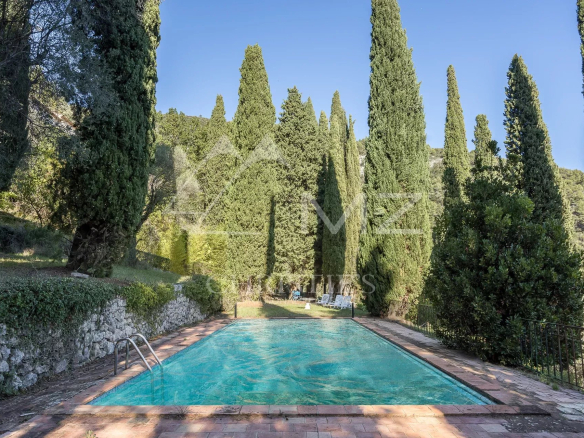 Swimming pool surrounded by cypress trees in a property in Tourrettes-sur-Loup.