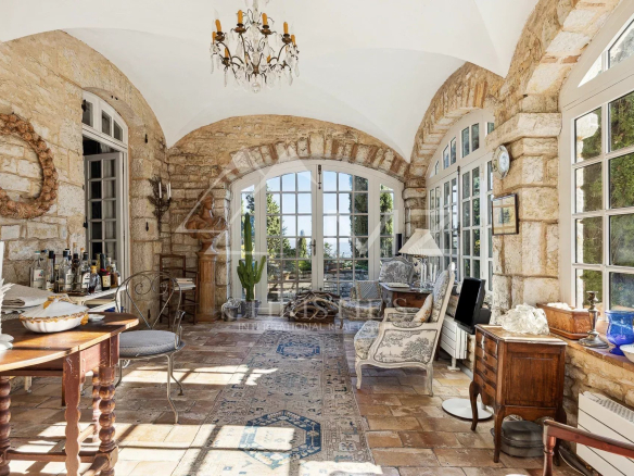 Interior of a manor house with stone walls, arched windows and elegant furnishings.