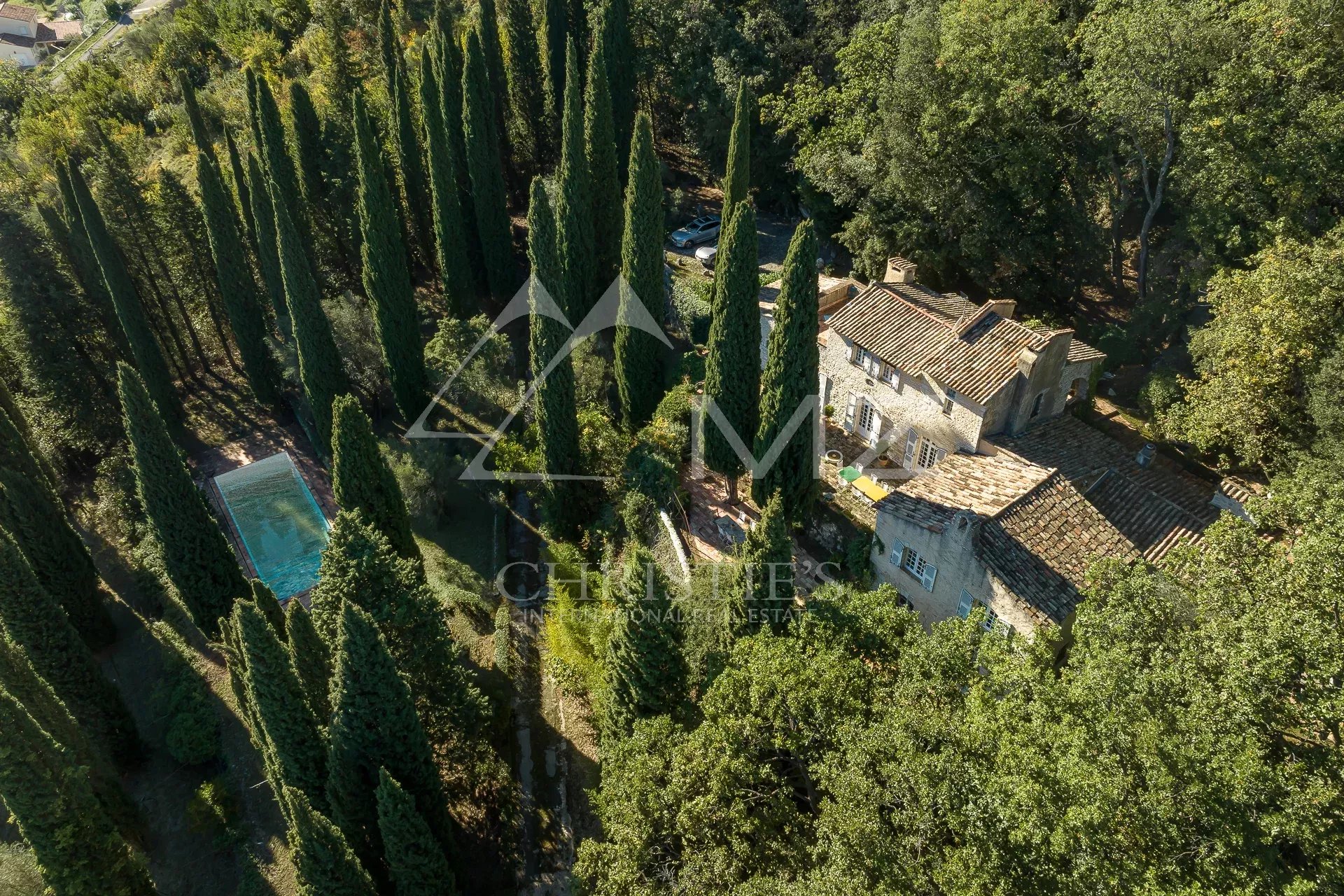 Aerial view of a mansion with swimming pool and wooded park in Tourrettes-sur-Loup.