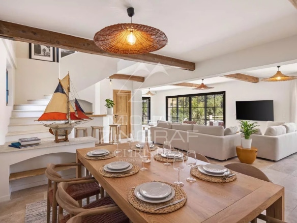 Intérieur d'une maison rénovée avec salle à manger et séjour lumineux, vue sur le village de Saint Paul de Vence