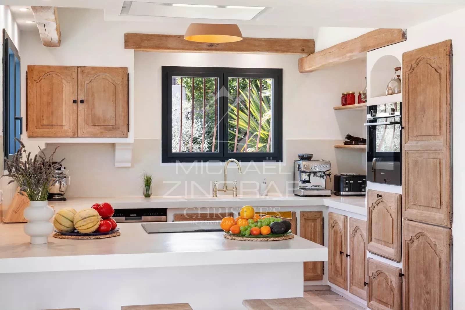 Cuisine rénovée avec vue Cuisine moderne et lumineuse avec des éléments en bois et des fruits sur le comptoir.