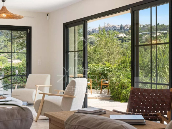 Vue panoramique sur le village de Saint Paul de Vence depuis un intérieur moderne.