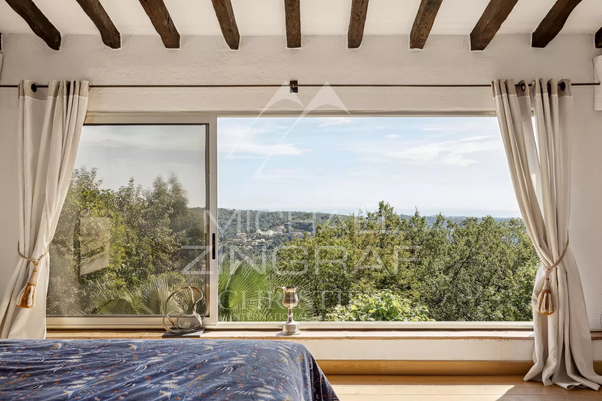 Sea view from a villa in Vence Panoramic sea view from a villa in Vence, with a bright interior and wide open windows.