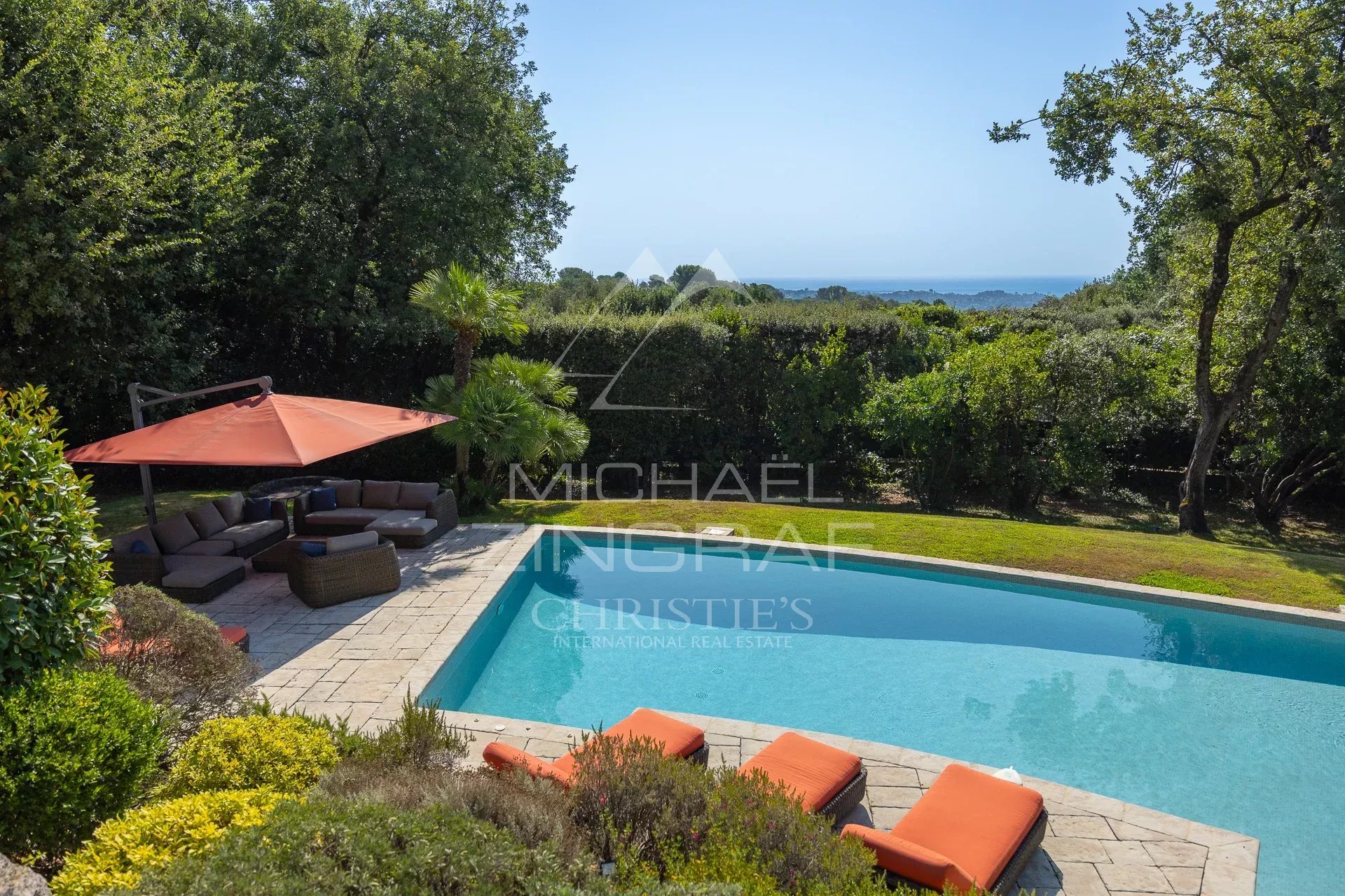Vue d'une propriété avec piscine et espace détente à La Colle-sur-Loup, entourée de verdure.