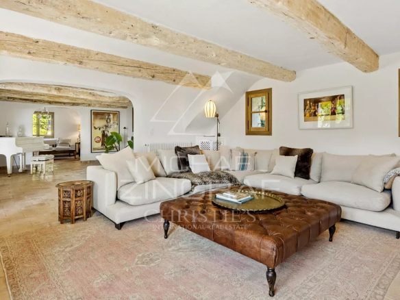 Intérieur d'une maison provençale rénovée avec un salon confortable et des poutres apparentes.