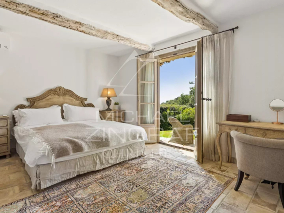 Chambre d'une propriété provençale à La Colle-sur-Loup, avec vue sur le jardin et accès à une terrasse.