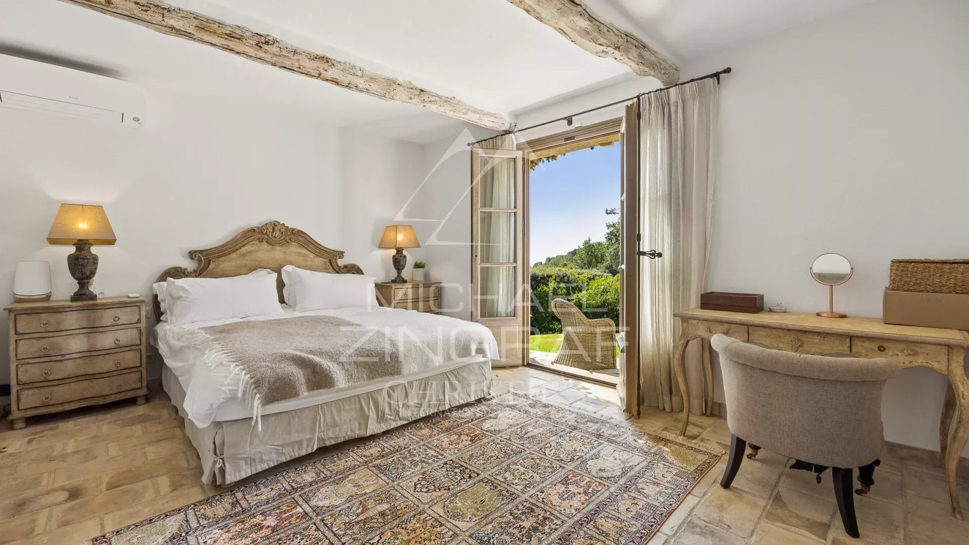 Chambre d'une propriété provençale à La Colle-sur-Loup, avec vue sur le jardin et accès à une terrasse.
