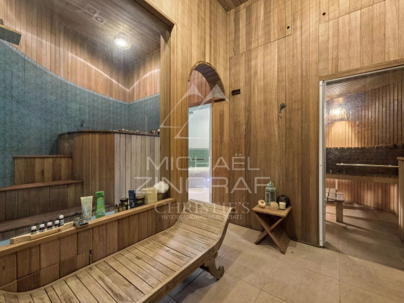 Intérieur d'un spa avec sauna en bois et carrelage bleu, éclairage doux.