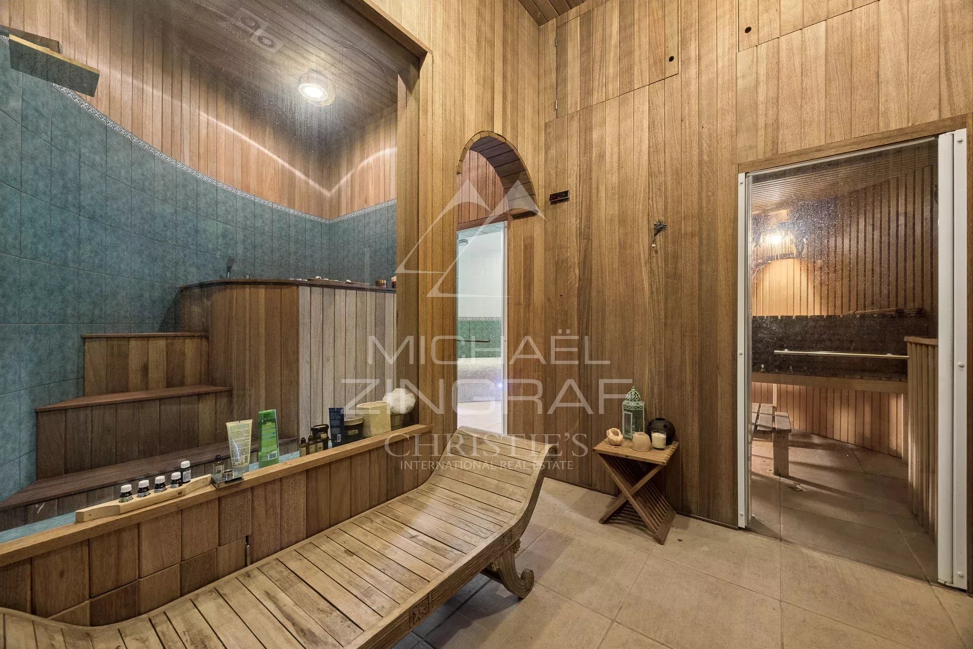 Spa intérieur d’une propriété néo-provençale Intérieur d'un spa avec sauna en bois et carrelage bleu, éclairage doux.