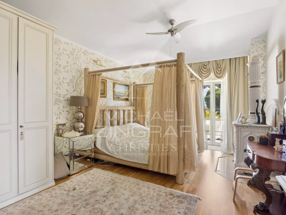 Chambre d'une propriété néo-provençale avec lit à baldaquin et décor élégant.
