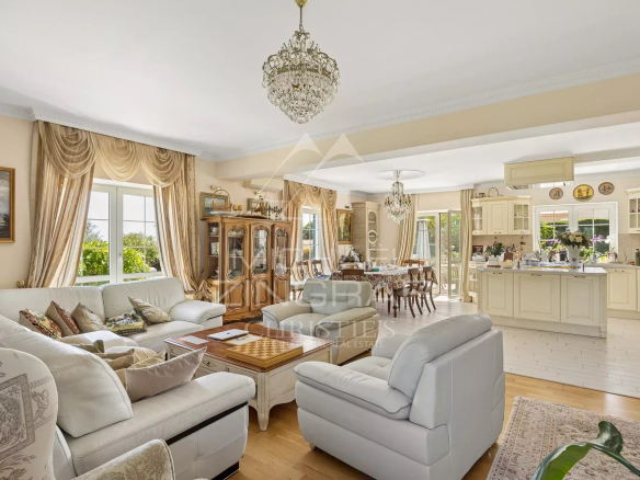 Intérieur d'une villa néo-provençale à Saint-Paul-de-Vence avec salon lumineux et cuisine ouverte.