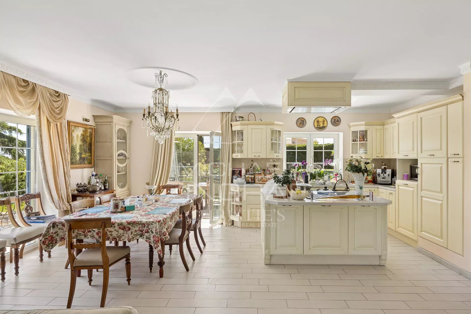 Cuisine élégante d’une propriété néo-provençale Intérieur d'une cuisine lumineuse avec une table à manger et des meubles en bois clair.