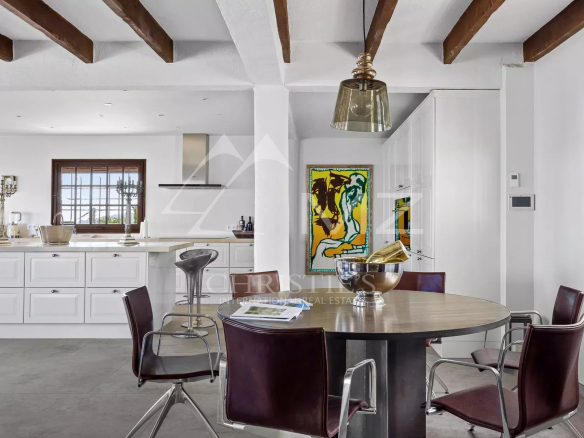 Interior of a Provençal villa with dining room and open kitchen.