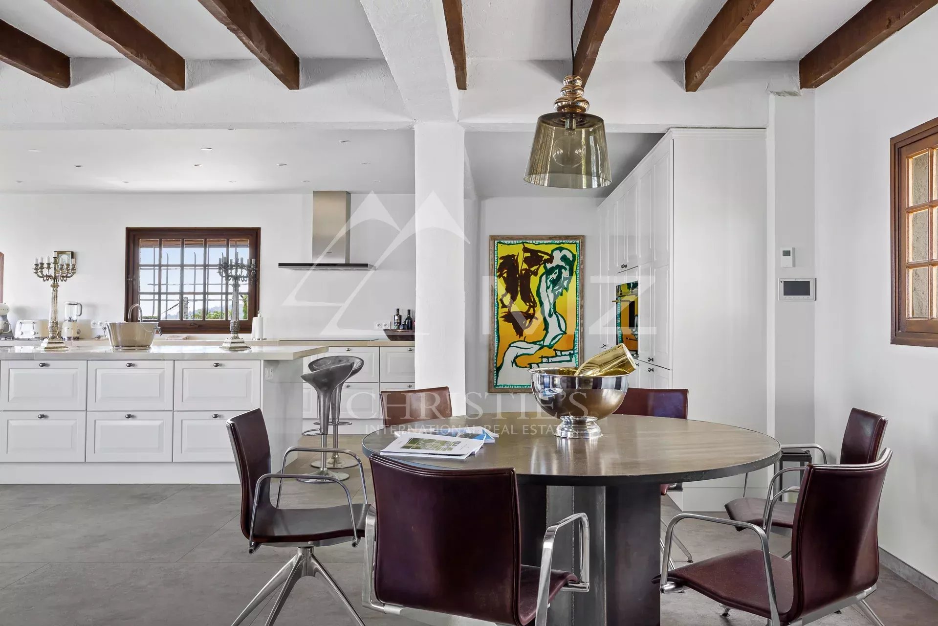 Interior of a Provençal villa with dining room and open kitchen.