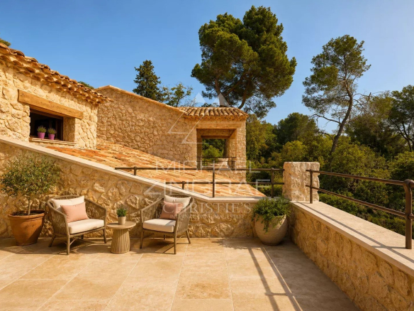 Terrasse en pierre avec chaises, vue sur la nature et la villa en arrière-plan à Saint-Paul-de-Vence.