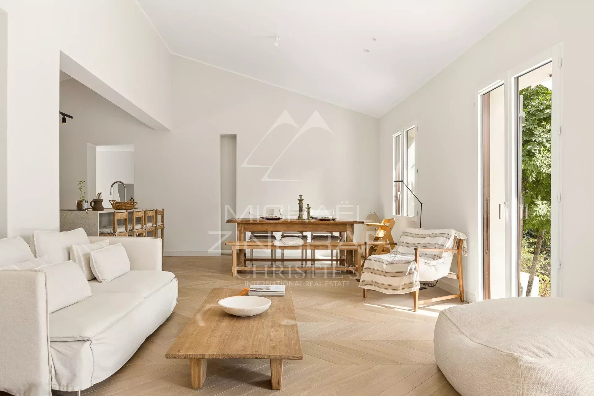Intérieur d’une villa rénovée Intérieur d'une villa rénovée avec un salon lumineux et des grandes fenêtres donnant sur un parc.