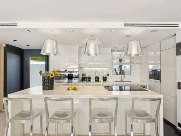 Cuisine moderne avec îlot central et bar, villa dans le domaine des Hauts de Vaugrenier à Villeneuve-Loubet.