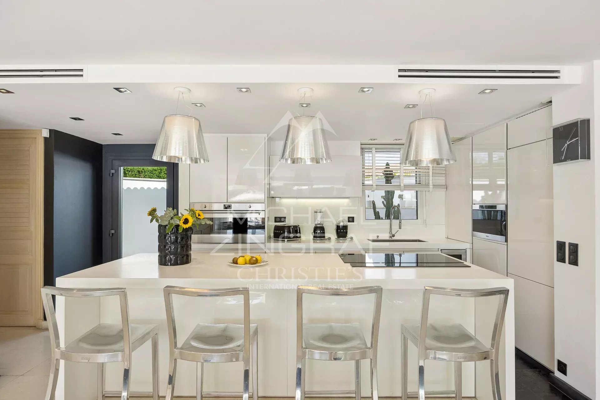 Cuisine moderne avec îlot central et bar, villa dans le domaine des Hauts de Vaugrenier à Villeneuve-Loubet.