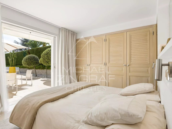 Chambre d'une villa avec lit et accès à une terrasse extérieure à Villeneuve-Loubet.
