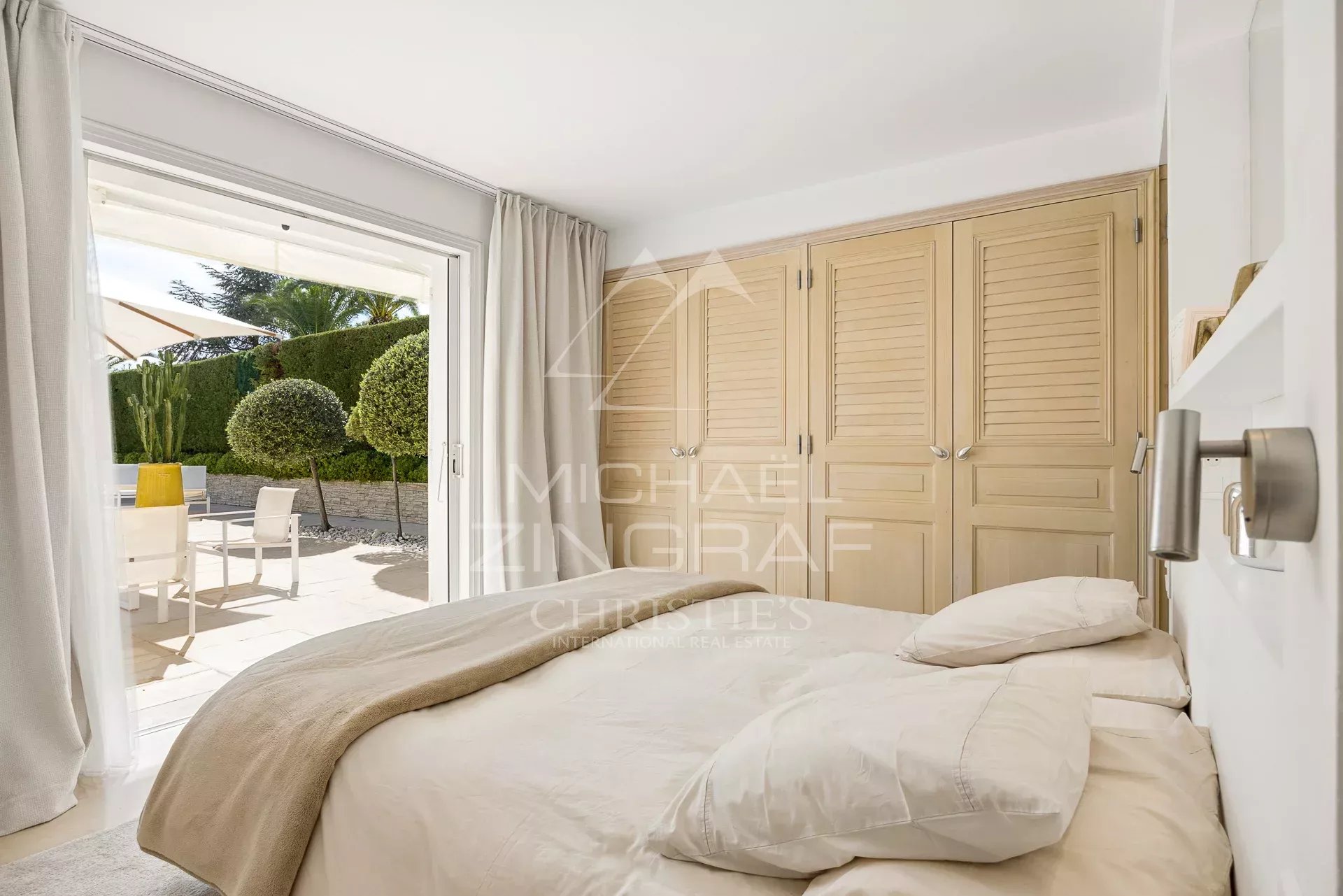 Chambre d'une villa avec lit et accès à une terrasse extérieure à Villeneuve-Loubet.