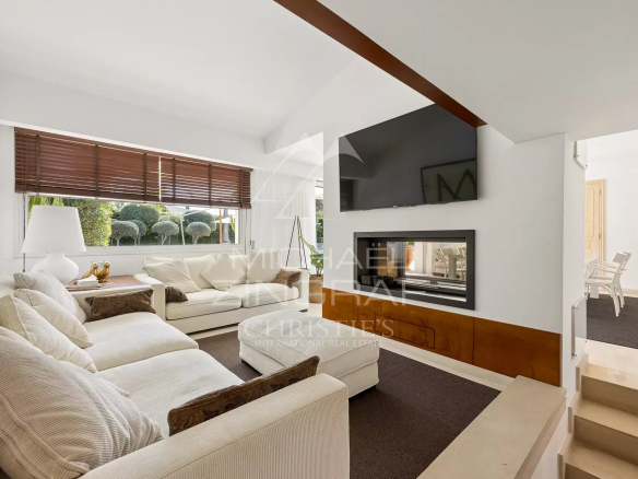 Intérieur d'une villa moderne avec salon lumineux et cheminée à Villeneuve-Loubet.