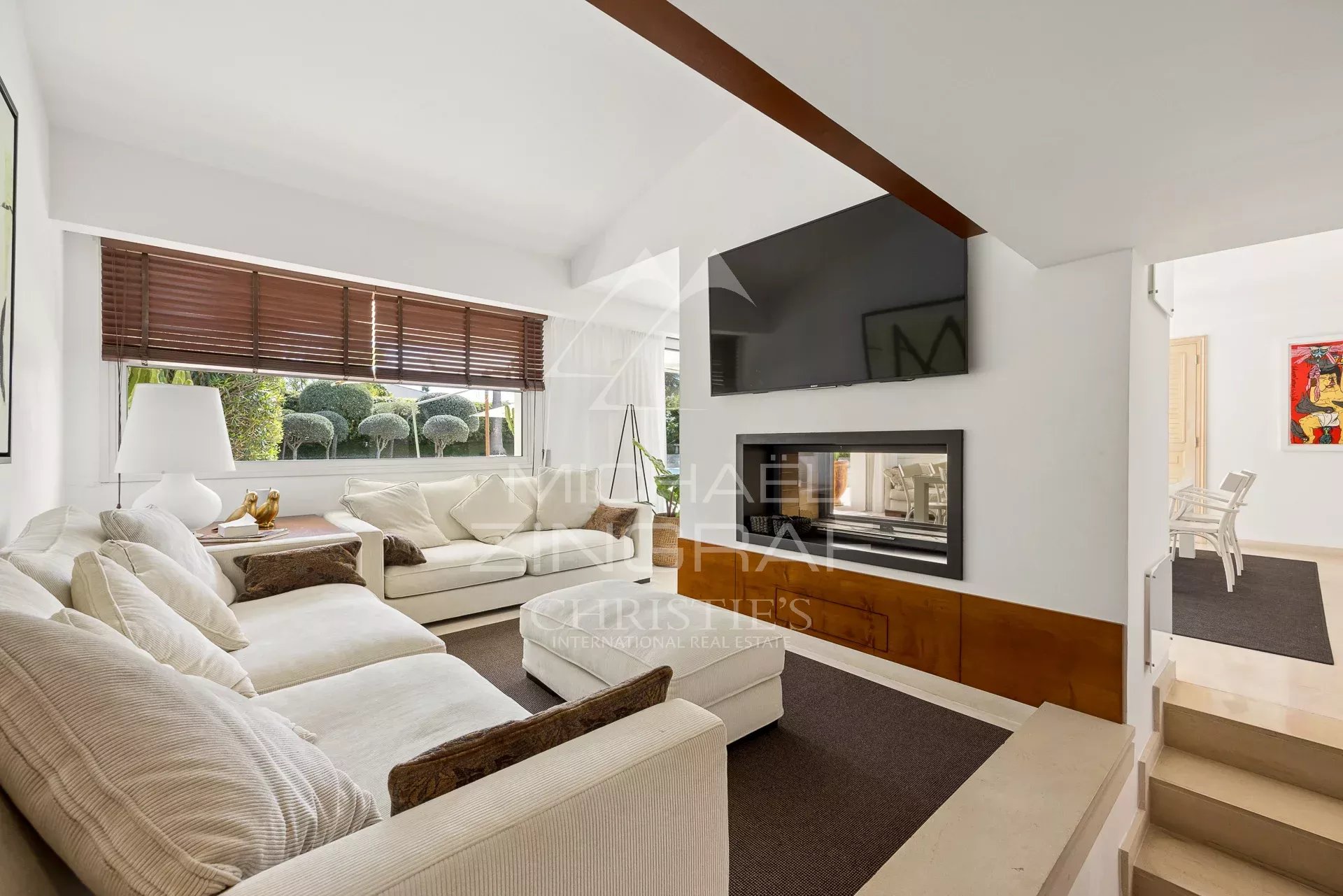 Intérieur d'une villa moderne avec salon lumineux et cheminée à Villeneuve-Loubet.