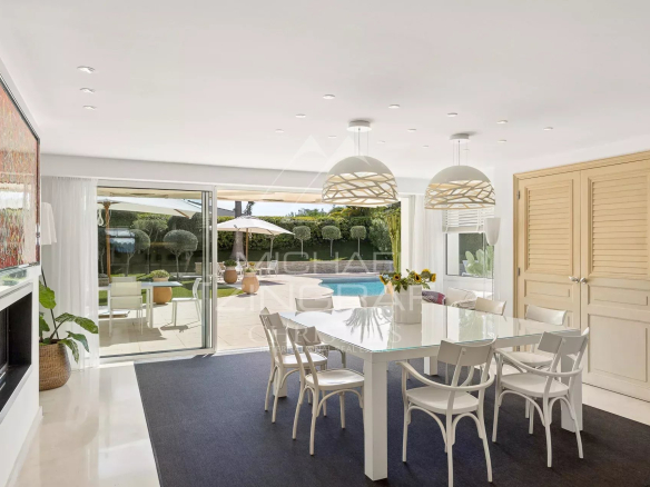 Intérieur d'une villa moderne avec salle à manger et accès à la piscine