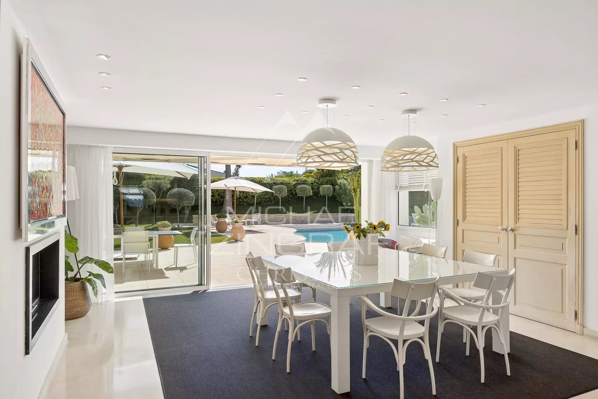 Intérieur d'une villa moderne avec salle à manger et accès à la piscine