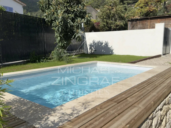 Piscine d'une propriété provençale rénovée à Tourrettes-sur-Loup, entourée de verdure et d'un aménagement soigné.