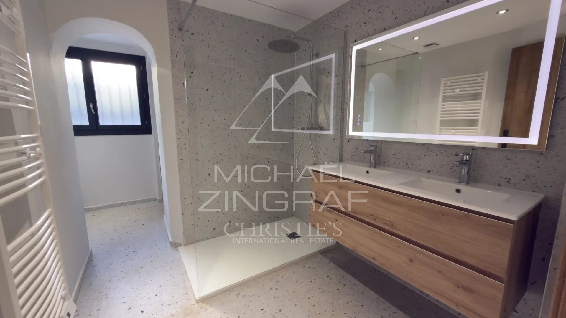 Salle de bain rénovée Salle de bain moderne avec douche et meuble en bois, murs en pierre, dans une propriété à Tourrettes-sur-Loup.