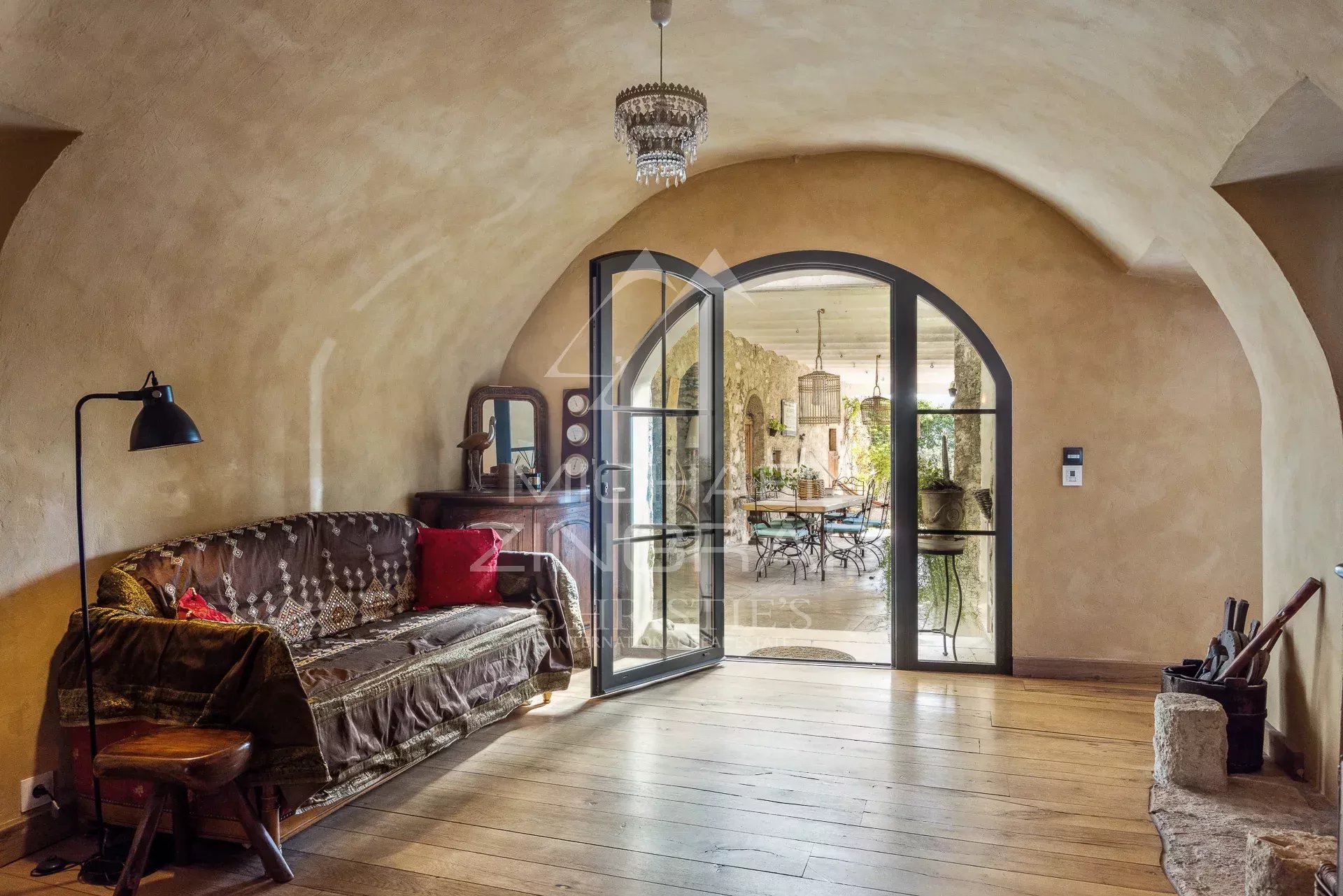 Intérieur d’une demeure à La Colle-sur-Loup Intérieur d'une maison avec un salon au style ancien et une porte vitrée donnant sur un espace lumineux.