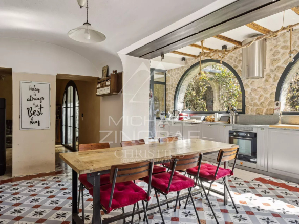 Cuisine moderne avec table en bois et chaises rouges dans une maison rénovée à La Colle-sur-Loup.