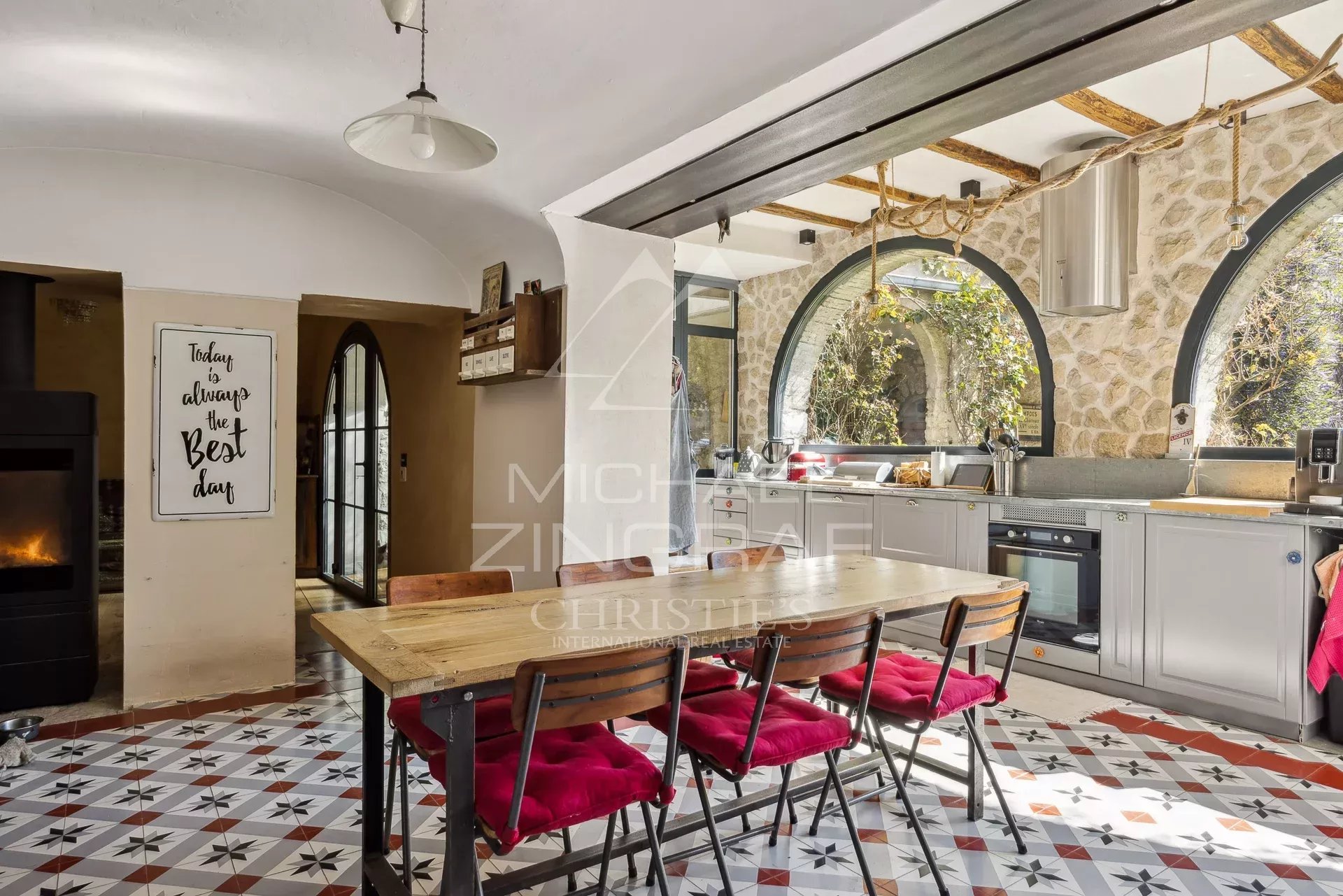 Cuisine rénovée à La Colle-sur-Loup Cuisine moderne avec table en bois et chaises rouges dans une maison rénovée à La Colle-sur-Loup.