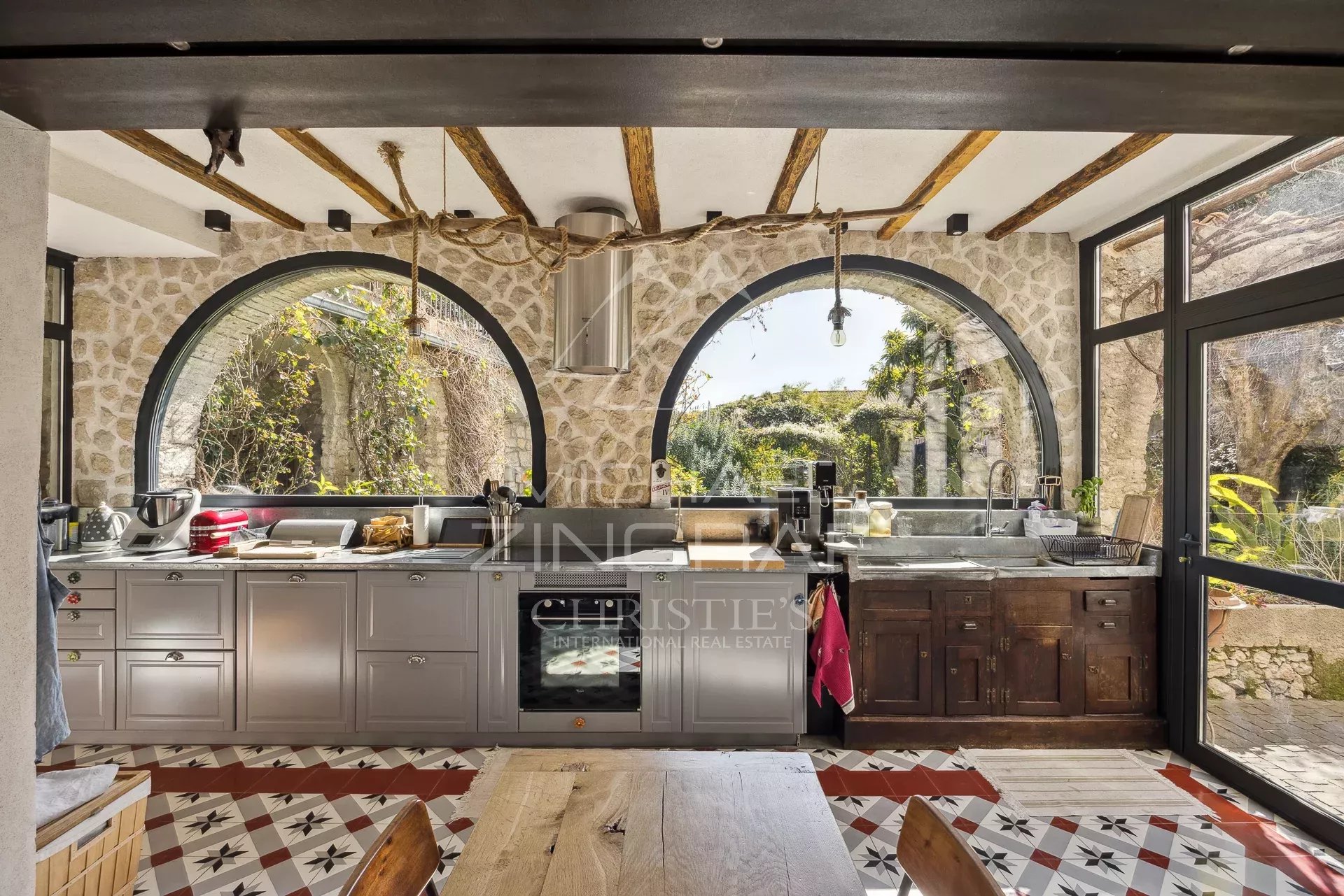 Cuisine au cœur de La Colle-sur-Loup Cuisine moderne avec fenêtres arrondies et vue sur le jardin, La Colle-sur-Loup.