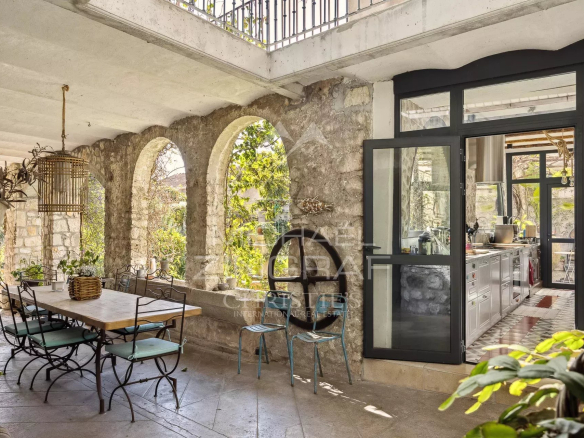 Intérieur d'une demeure rénovée avec des arches en pierre et une cuisine moderne à La Colle-sur-Loup.