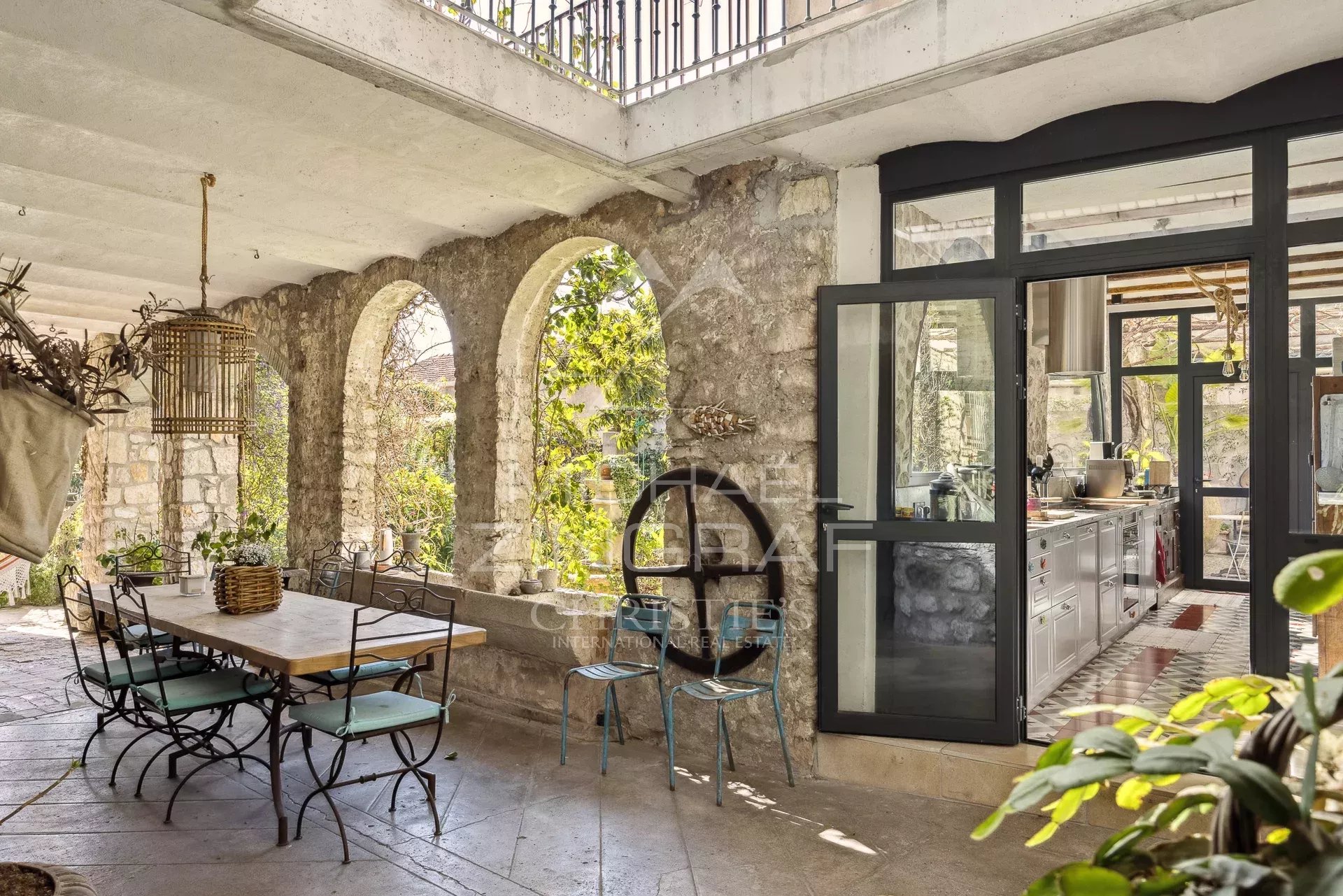 Demeure rénovée à La Colle-sur-Loup Intérieur d'une demeure rénovée avec des arches en pierre et une cuisine moderne à La Colle-sur-Loup.