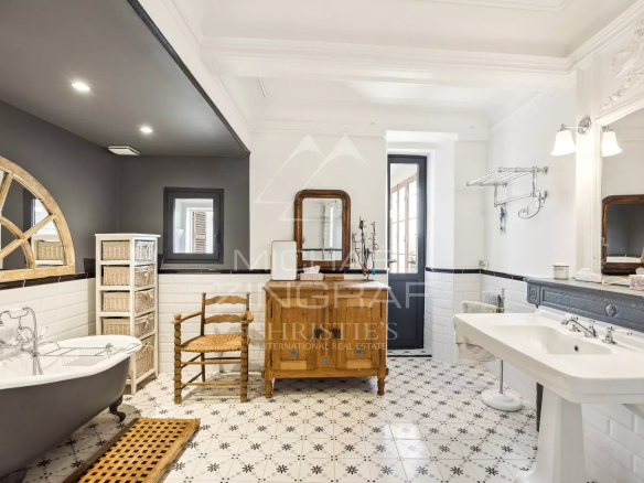 Salle de bain élégante avec baignoire sur pied et carrelage en mosaïque.
