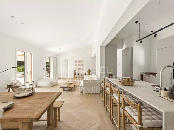 Interior of a renovated villa with open kitchen and dining room, bright and modern.
