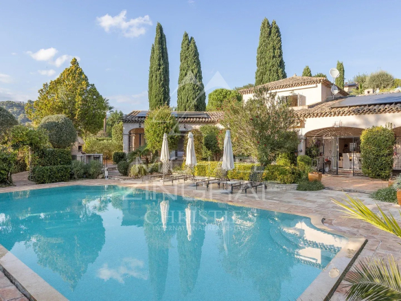 Propriété avec piscine et jardins à Saint-Paul-de-Vence, entourée d'arbres et de terrasses.