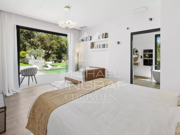 Chambre d'une villa contemporaine avec vue sur le jardin et la piscine à Roquefort-les-Pins.