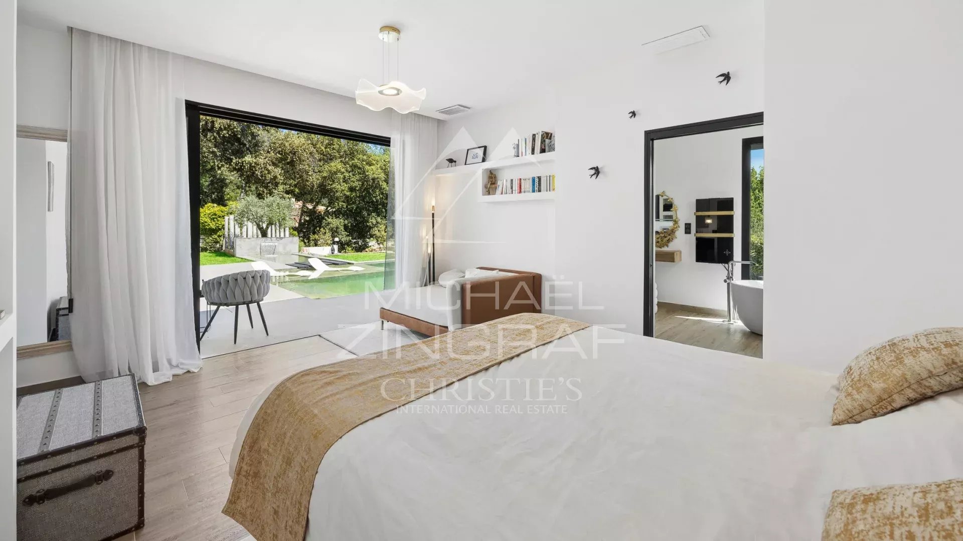 Chambre moderne dans une villa à Roquefort-les-Pins Chambre d'une villa contemporaine avec vue sur le jardin et la piscine à Roquefort-les-Pins.