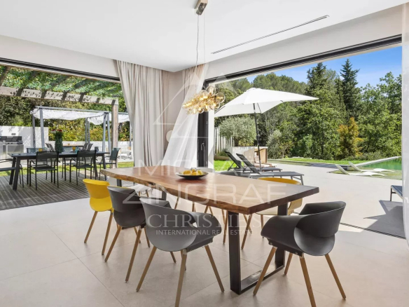 Intérieur d'une villa contemporaine avec salle à manger et vue sur le jardin.