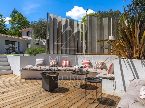 Terrasse en bois avec mobilier de jardin dans une villa contemporaine à Roquefort-les-Pins.