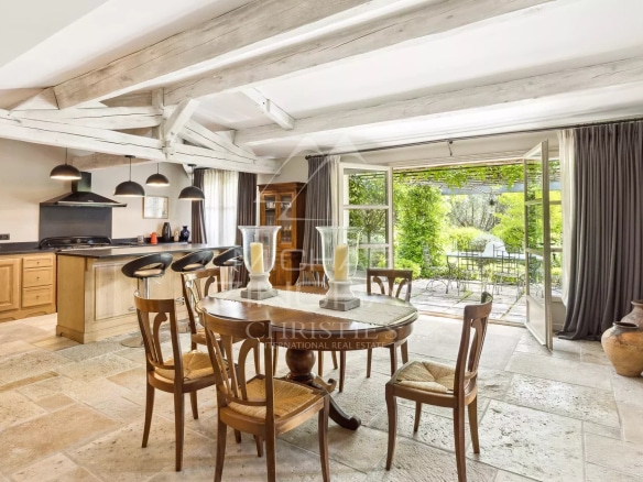 Intérieur d'une villa en Provence avec cuisine ouverte et salle à manger, vue sur le jardin.