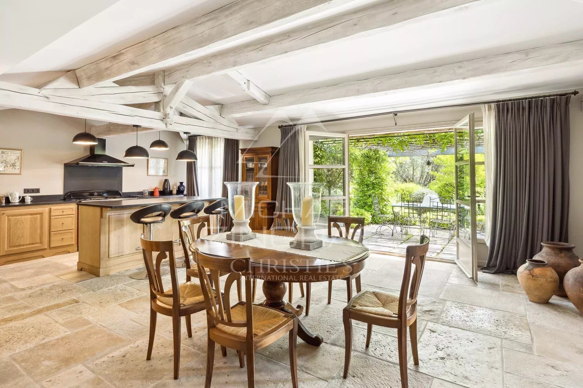 Intérieur d'une villa en Provence avec cuisine ouverte et salle à manger, vue sur le jardin.