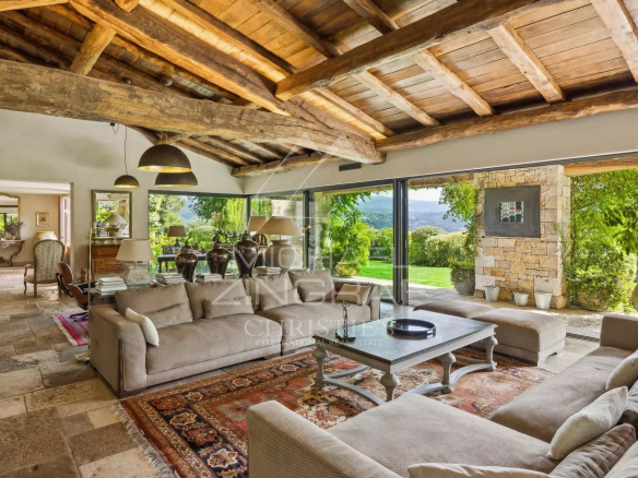 Intérieur d'une villa provençale avec vue sur la vallée, salon spacieux et lumineux.